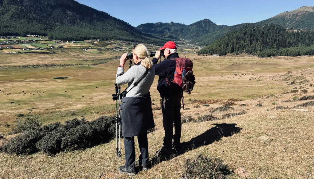 Travellers birdwatching in the Himalayan landscape of Bhutan